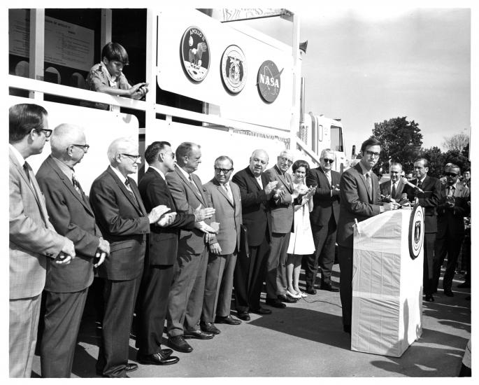 Group stands in front of tour trailer. 