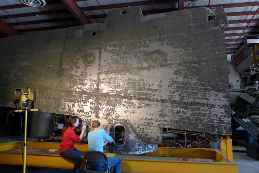 Two conservators in front of wing. 