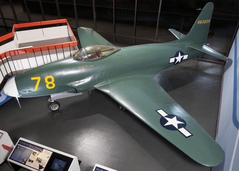 Side view of dark green military monoplane with one engine. Monoplane is on display in the museum.