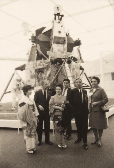 Black and white photo of dignitaries posing in front of the Lunar Module. 