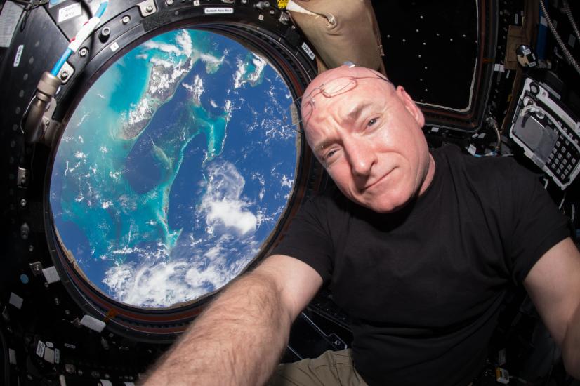 A photograph of Kelly with a view of the Earth in the background. 