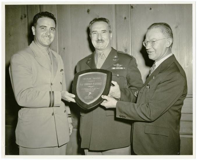 Two men present plaque to man between them