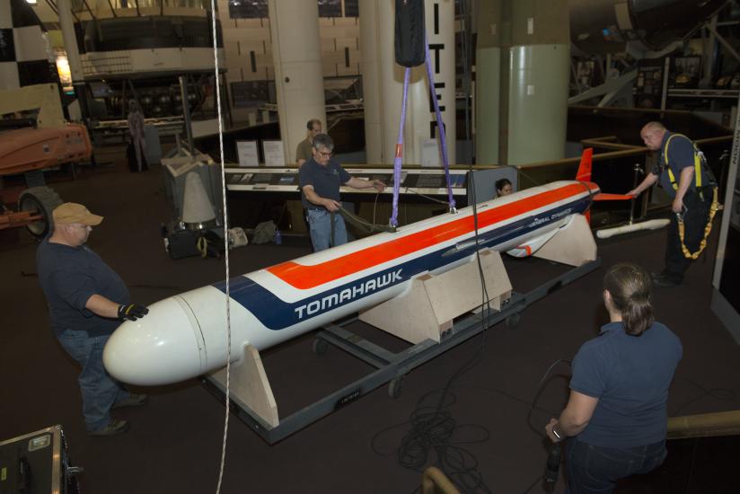 Staff encircle the missile as it is lowered to the ground