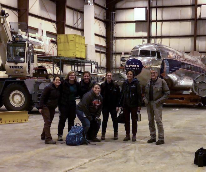 A group of people gather and smile at the camera. 