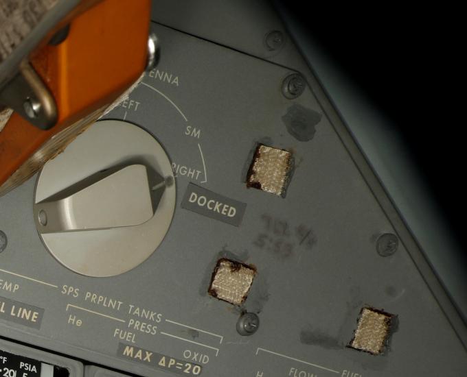 A close-up view of part of the Apollo 11 control panel with writing and velcro on the panel.