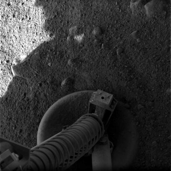 Black and white photo of the lander's leg on the Martian surface.