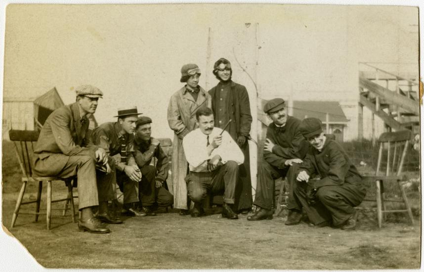 Five men and two women watch a man pointing