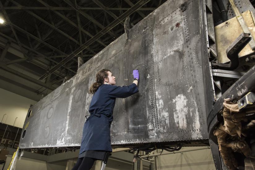 woman looks at aircraft paint