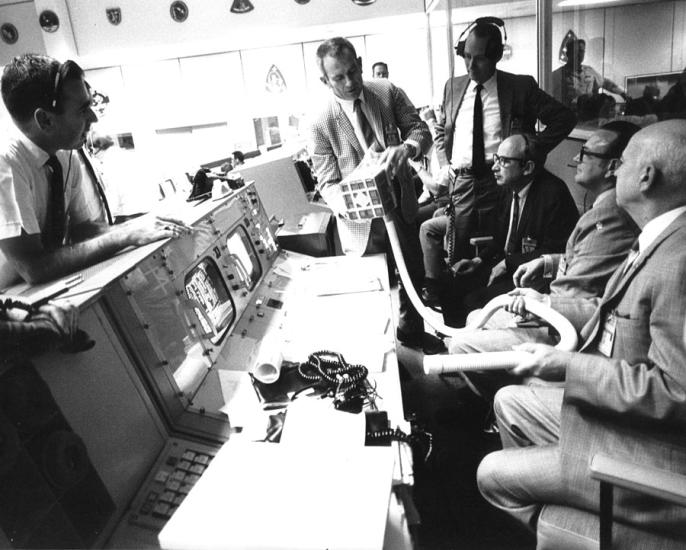 group of men around mission control desk