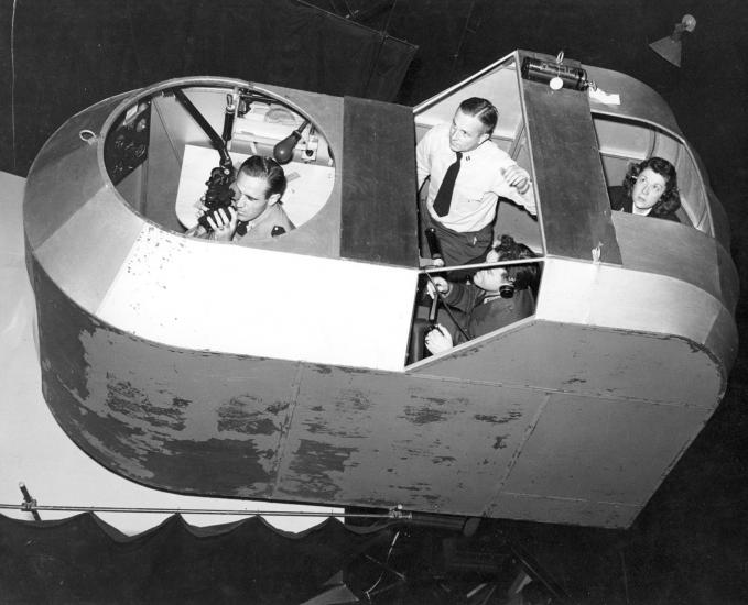 A woman with three male students in a simulator. 