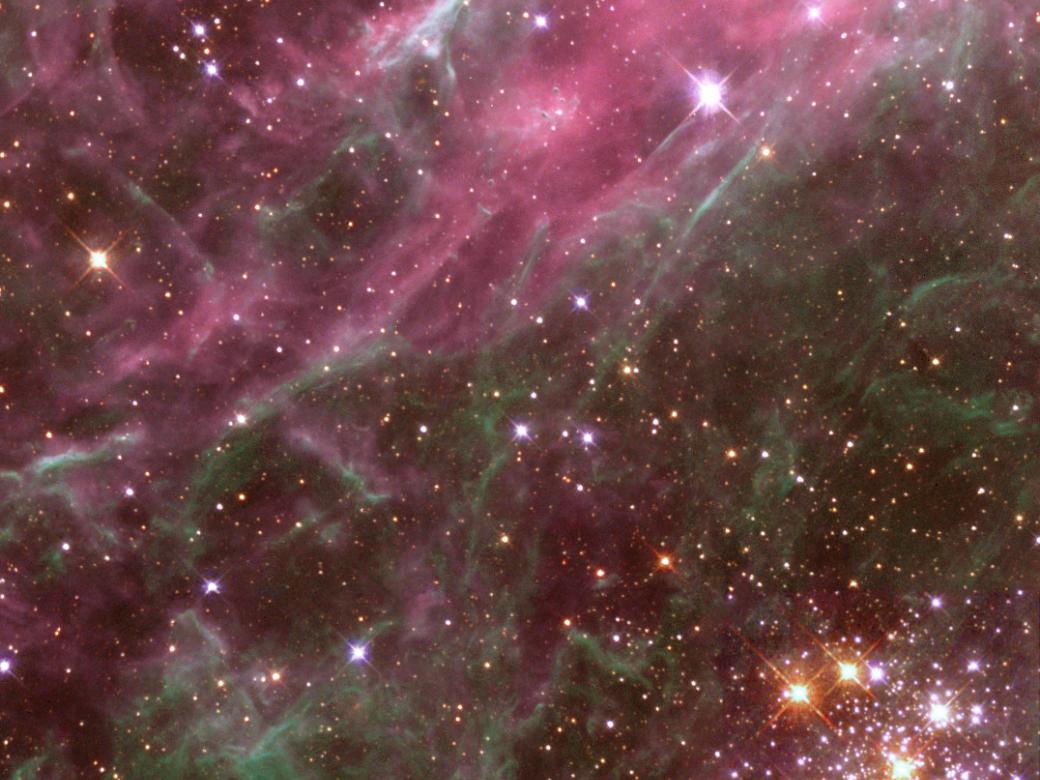Stars are found throughout a gray and pink nebula.