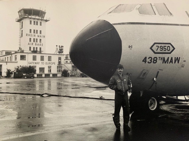 Alan W. Christensen in uniform standing in front of plane.