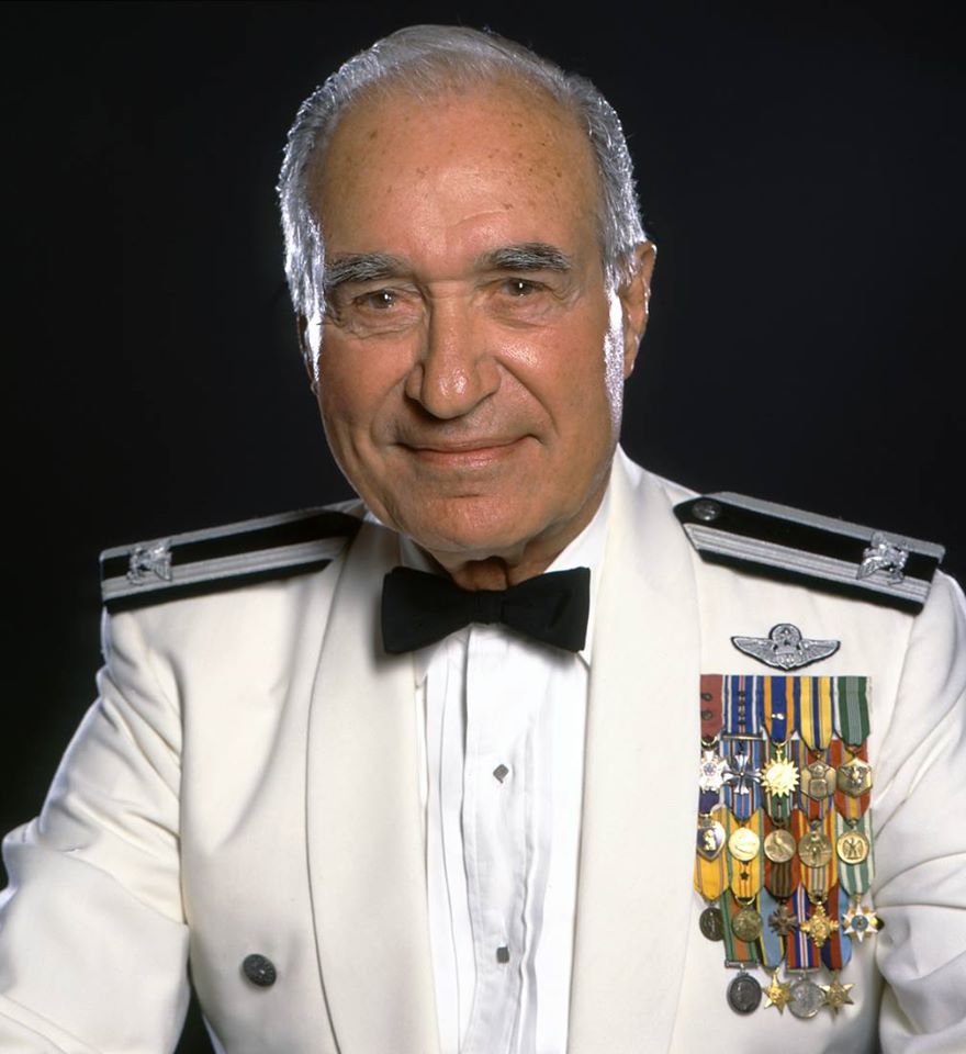 Col. Pisanos in white uniform with medals.